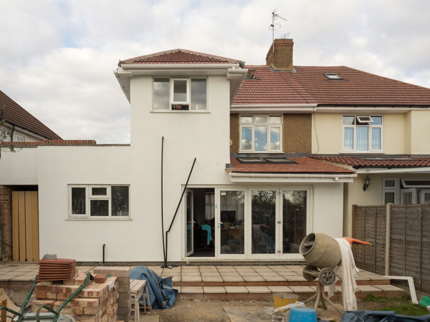 House undergoing renovation with construction supplies on the patio.